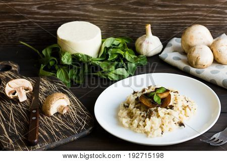 Risotto With Mushrooms On A Dark Wooden Background