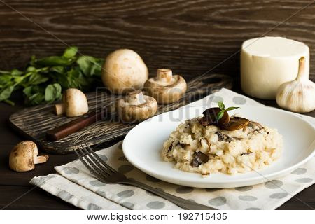Risotto With Mushrooms On A Dark Wooden Background