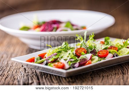 Vegetable salad. Plate of salad with vegetables on rustic oak table. Assortment of ingredients of vegetable salad.