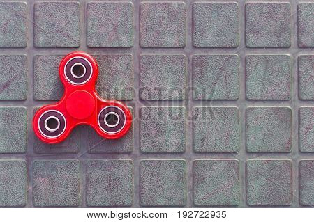 Top view of the popular red spinner gadget in 2017 on the blue-green background