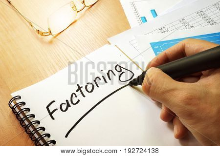 Factoring written by hand in a note.
