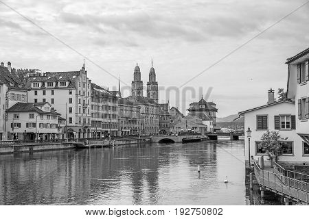 Downtown view of Zurich from bridge Rudolf-Brun-Brucke Grossmunster town hall and river Limmat in front - black and white.
