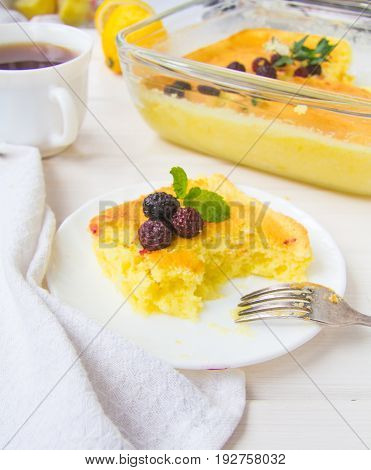 Homemade English lemon pudding with blackberries and a cup of tea