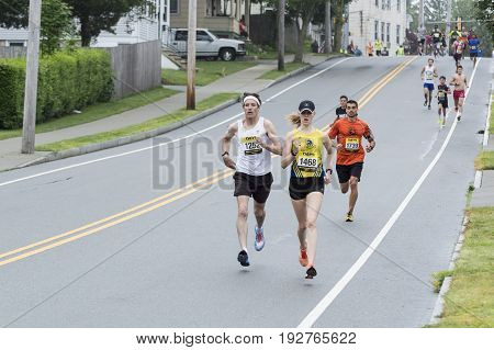 Fairhaven Massachusetts USA - June 18 2017: Runners pick up pace on short downhill section in Fairhaven Road Race