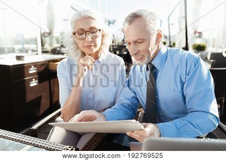 Let me see it. Supercilious blonde sitting next to her worker, wrinkling forehead while holding right arm near chin