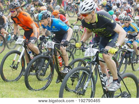 STOCKHOLM SWEDEN - JUNE 11 2017: Side view of group of fighting male mountain bike cyclists cycling uphill at Lida Loop Mountain bike Race audience in background. June 11 2017 in Stockholm Sweden