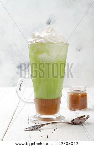 Matcha latte with salted caramel in tall glass.