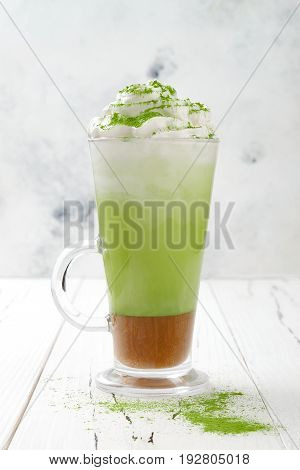 Matcha latte with salted caramel in tall glass.