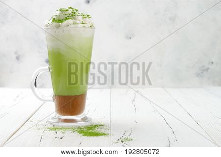 Matcha latte with salted caramel in tall glass. Copy space