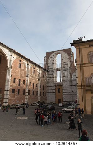 Italy Siena - December 26 2016: the view of the people on a square in front of incomplete facade of the planned Duomo nuovo. Facciatone on December 26 2016 in Siena Tuscany Italy.