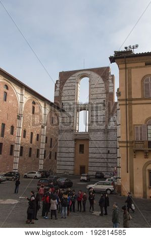 Italy Siena - December 26 2016: the view of the people on a square in front of incomplete facade of the planned Duomo nuovo. Facciatone on December 26 2016 in Siena Tuscany Italy.