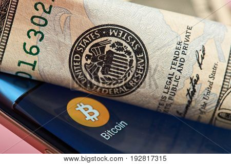 New york, USA - June 26, 2017: Bitcoin mobile application close-up against federal reserve system.Bitcoin against dollar system