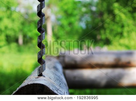 Metal spiral drill for making holes in logs when assembling a wooden frame and building a house.