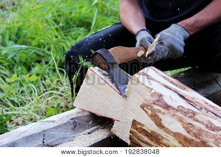 The worker collects a wooden frame with the help of an hacket during the construction of a house.