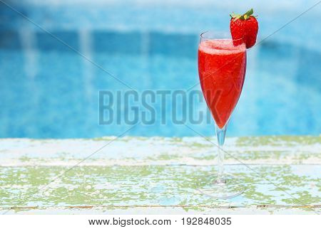 Champagne glasses with strawberry on turquoise background. Rossini cocktail. Summer pool party
