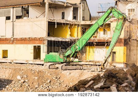 Excavator in front of a demolition site