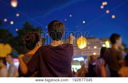 Teens in summer night with watching paper lantern