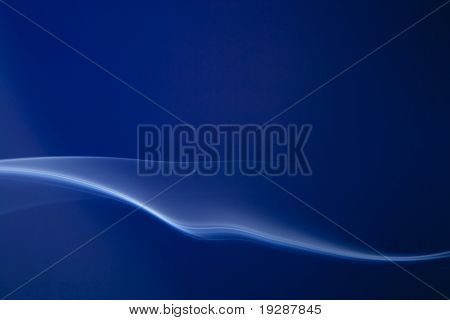 Whisp azul de humo que fluye horizontalmente sobre fondo azul real profundo.