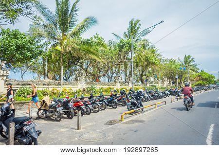 BALI- INDONESIA MARCH 08. 2017: Unidentified motorcyclist rides down the street. Legian's area. Legian is a suburban and beach area on the west coast of Bali.