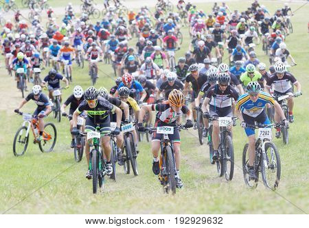 STOCKHOLM SWEDEN - JUNE 11 2017: Lots of mountain bike cyclist struggling in a steep uphill at Lida Loop Mountain bike Race. June 11 2017 in Stockholm Sweden