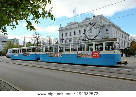 GOTHENBURG SWEDEN - MAY 2017: Blue old electric train running in Gothenburg Sweden. Building on a background is Stora Teatern -Gothenburg's scene for Swedish and international performances.