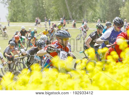 STOCKHOLM SWEDEN - JUNE 11 2017: Group of men and woman leading his mountain bike uphill competitors behind at Lida Loop Mountain bike Race audience in background. June 11 2017 in Stockholm Sweden