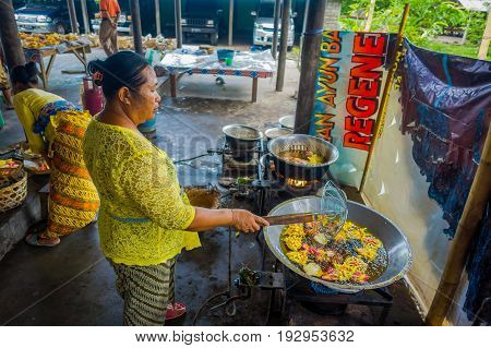 BALI, INDONESIA - MARCH 08, 2017: Women preparing an Indian Sadhu dough for chapati on Manmandir ghat on the banks of the holy river Ganges in Varanasi.