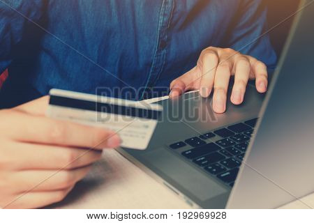 Close up smart young man typing trackpad on laptop with shopping online or internet banking concept.