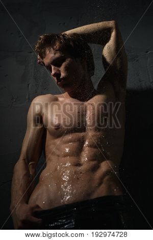 Athletic handsome man taking shower nude studio portrait