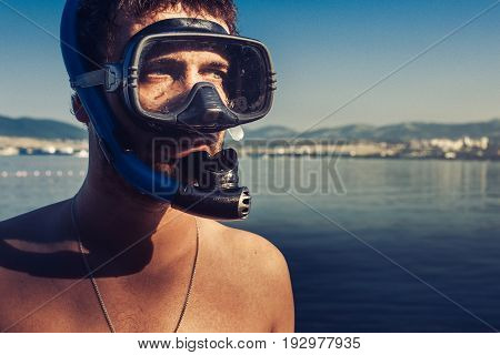 Male Scuba Diver With Mask And Snorkel Standing On The Beach On Sea Shore Background