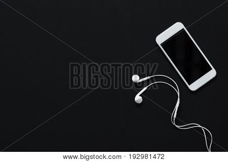 Modern Smartphone With Blank Screen And Earphones Isolated On Black