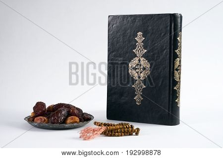 Islamic Holy Book Quran/ Kuran With wooden prayer beads Rosary and dry Dates Over white Background