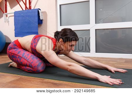 Young Sporty Woman Practicing Yoga, Doing Mahamudra Stretching Position In A Fitnes Club