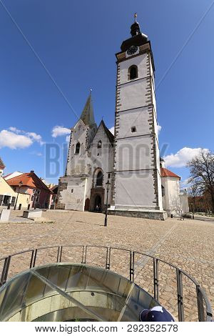 Very High White Church Tower Of The Pisek Church On The Blue Sky