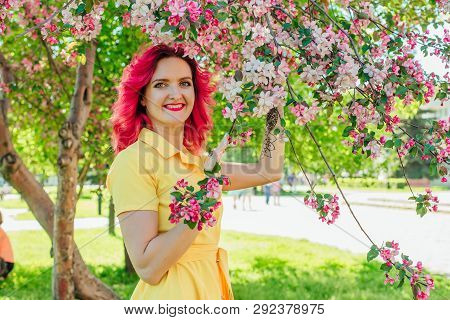 Beautiful And Young Woman With Bright Red Hair And Ref Lips Standing Next To A Blooming Apple Tree I