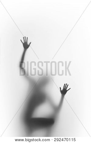 Woman Squatter, And Climb. Human Body Silhouette Can Be Seen Blurred Behind A Diffuse Surface, Only 