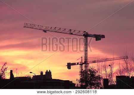 Sunset And Cranes Building The Housing Bubble