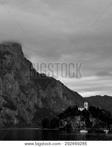 Vintage Black And White View Over Austrian Alps Lake. Boats, Yachts Infront Of Church On The Rock Wi