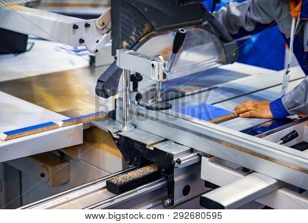 Carpenter worker operating wood cutting machine. CNC woodworking wood processing machine, modern technology in the industry.