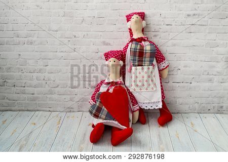 Tilda Doll, Soft Toy With A Heart, Sitting On A Wooden Background. Handcraft Concept. There Is A Pla