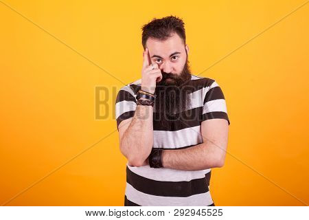 Bearded Hipster Young Man Thinking Over Yellow Background