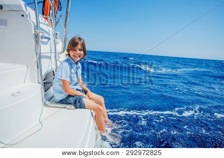 Little Boy On Board Of Sailing Yacht On Summer Cruise. Travel Adventure, Yachting With Child On Fami