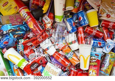 Many Wrappings And Cans From Used Products By Famous Worldwide Brands. Pattern Of Trash Of Various C
