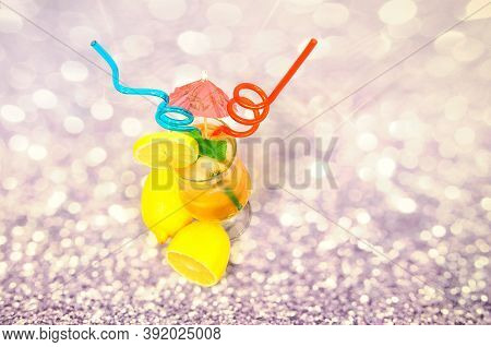 A Tall Glass Of Lemon Juice With Ice And A Slice Of Fruit On The Side, Decorated With Straws And An