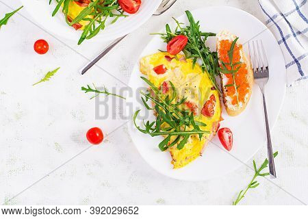 Omelette With Tomatoes, Cheese, Ham And Sandwich Wich Red Cavier On Plate.  Frittata - Italian Omele
