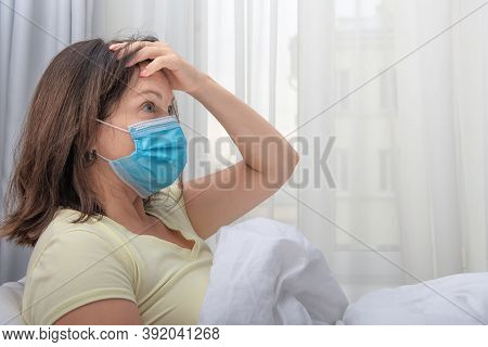 Coronavirus. Woman Wearing Medical Face Mask In Holding Hand On Her Forehead. Bedrest Is Important P
