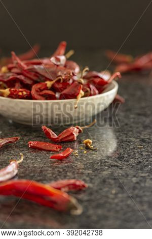 Dried Red Chili Or Chilli Cayenne Pepper In Grey Bawl On Black Marble Background, Close Up