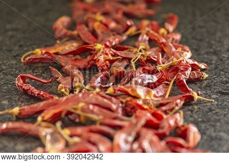 Dried Red Chili Or Chilli Cayenne Pepper On Black Marble Background, Close Up, Selective Focus