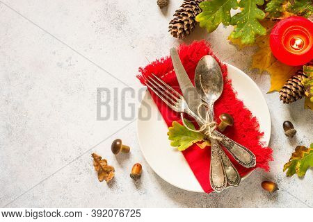 Thanksgiving Food Concept. Autumn Table Setting With White Plate, Silverware And Fall Decorations At