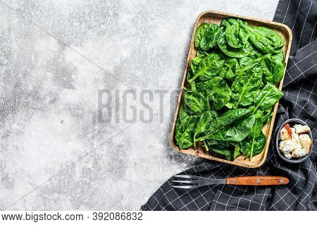 Fresh Spinach Salad In A Wooden Bowl With Goat Cheese. Gray Background. Top View. Copy Space